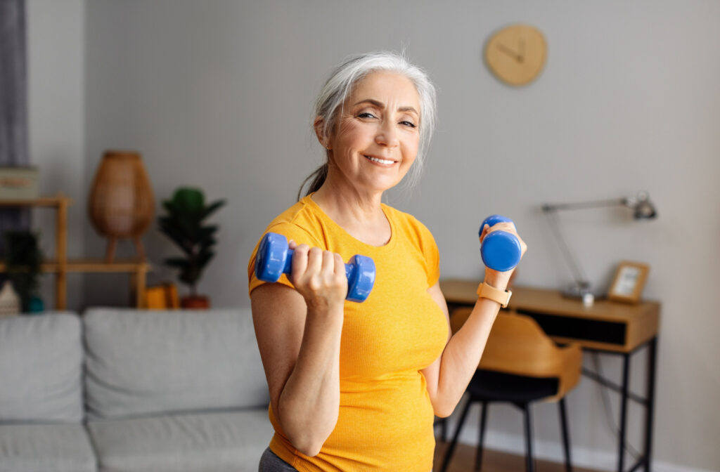 A smiling senior woman exercising with dumbbells