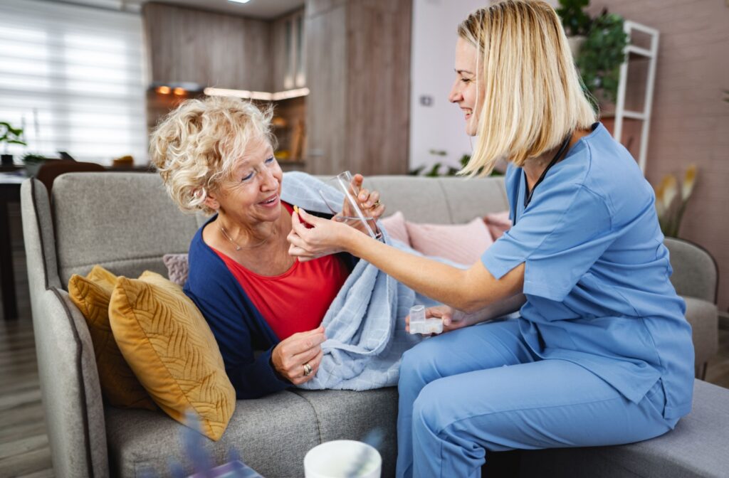 A nurse hands a senior a pill to help them manage their daily medication, so they don’t have to worry about forgetting a dose