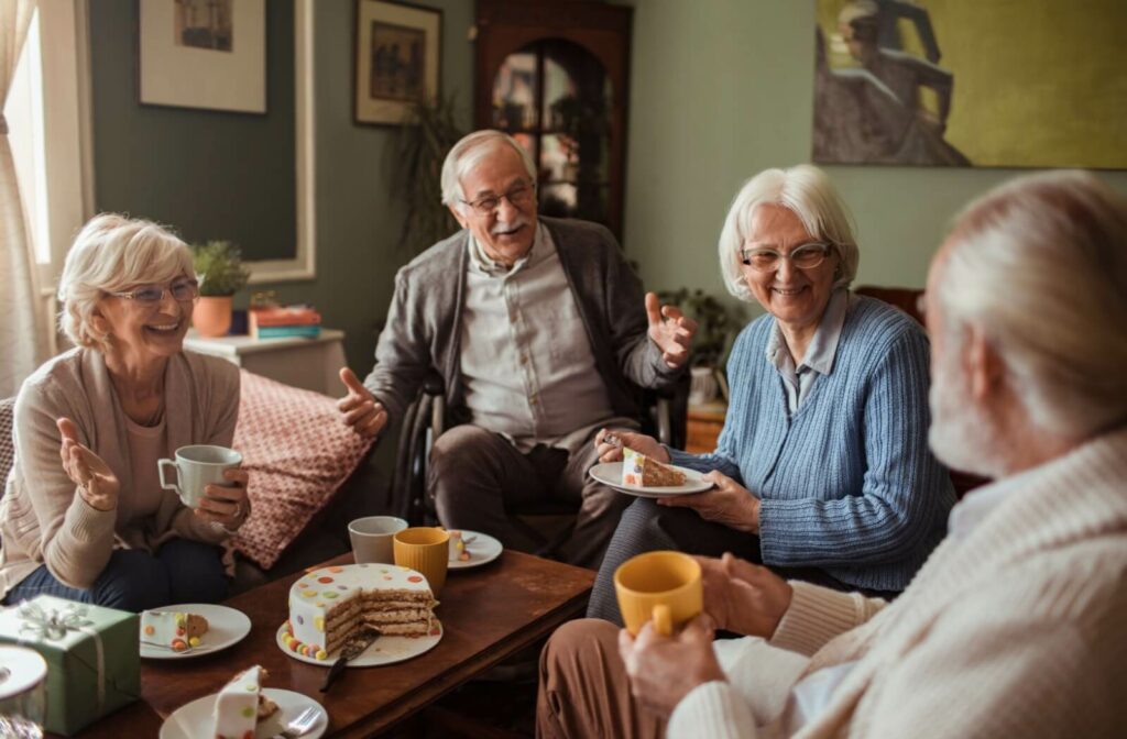 A group of seniors enthralled in conversation together over tea and cake in an afternoon in assisted living