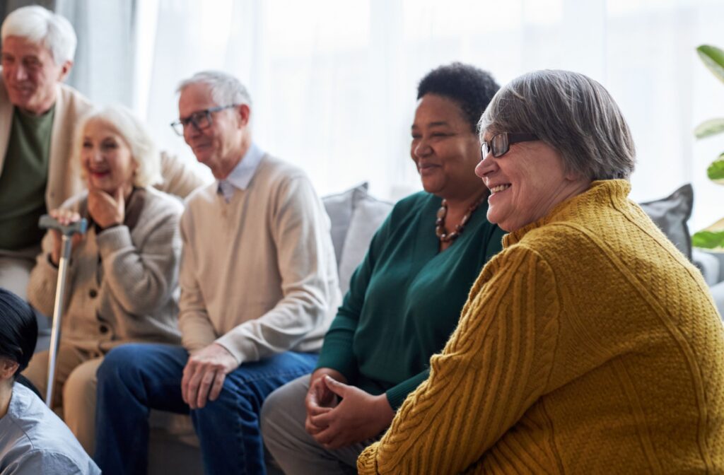 A group of smiling older adults sits together and enjoys an engaging conversation.